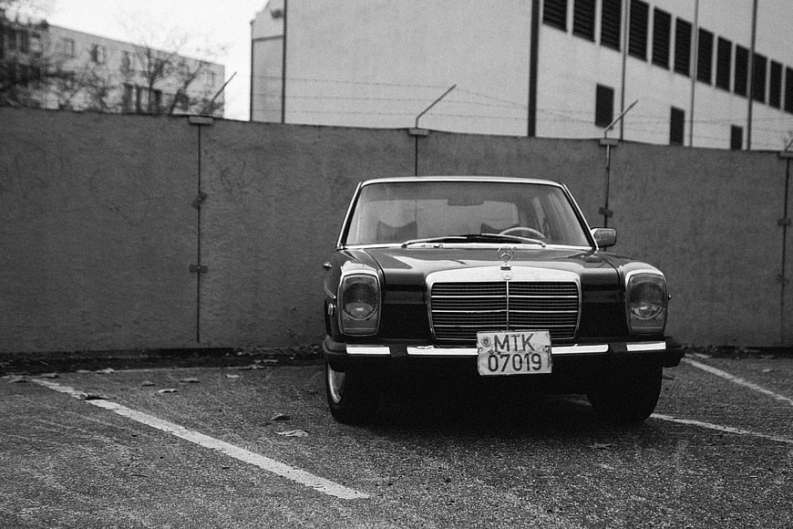 Vintage Black Mercedes-Benz W123 Parked in Grayscale