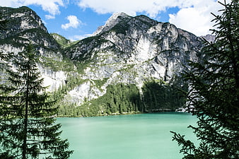 Turquoise alpine lake framed by pine trees and rocky mountains