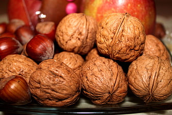 Close-up of walnuts and chestnuts with apples on a plate