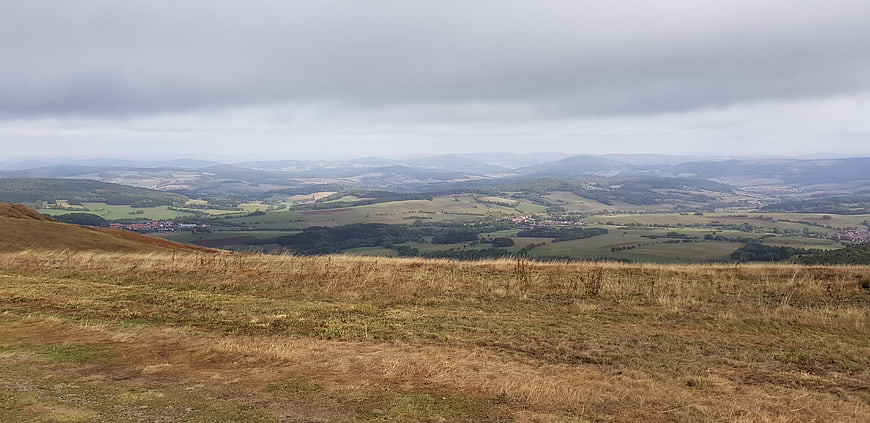 Panoramic View of Rolling Hills and Green Valleys Under Cloudy Sky