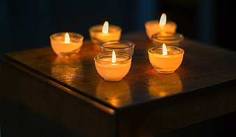 Tealight candles on wooden table in dim lighting
