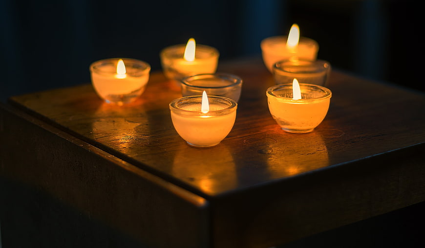 Tealight candles on wooden table in dim lighting