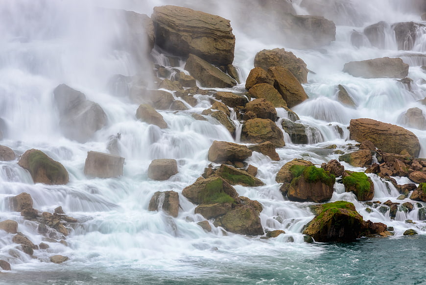 Majestic waterfall cascading over mossy rocks with long exposure