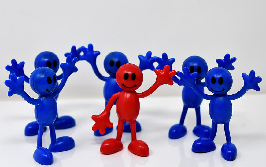 Red leader figure standing among blue team members