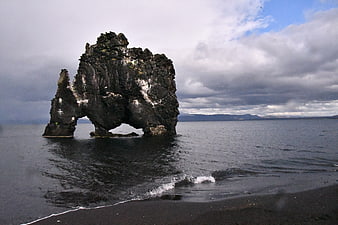 Dramatic sea stack on black sand beach Iceland