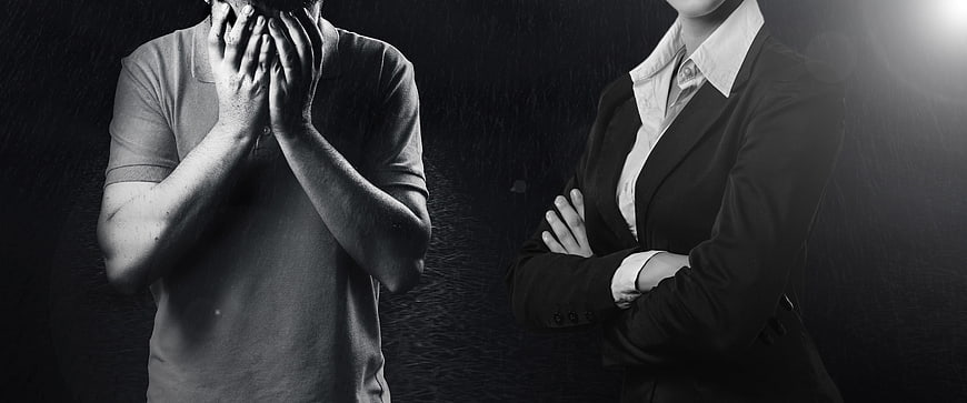 Sad man covering face and confident businesswoman with crossed arms