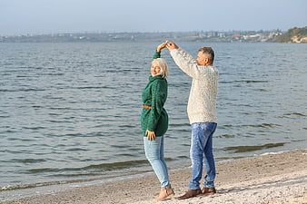 Happy Senior Couple Dancing on Sandy Beach by Sea