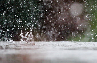 Raindrop Splash on Wet Surface with Blurred Green Background