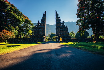 Bali Temple Gateway With Lush Tropical Garden And Distant Mountains