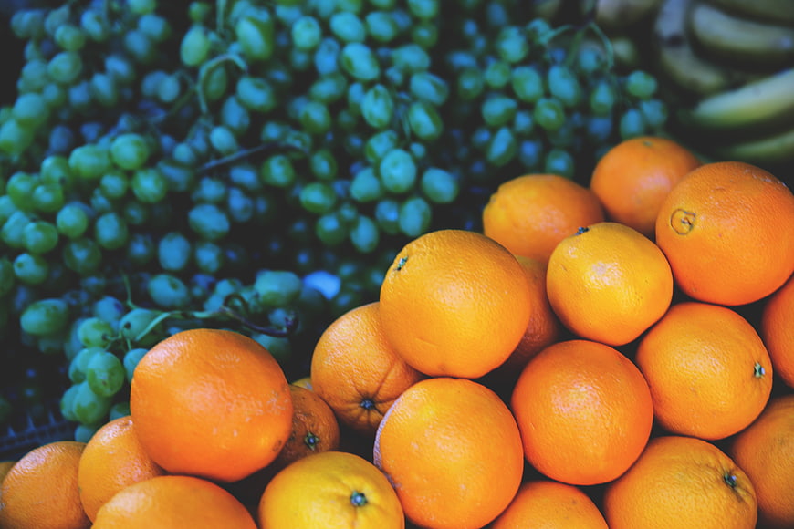 Fresh Oranges And Green Grapes At A Market Stall