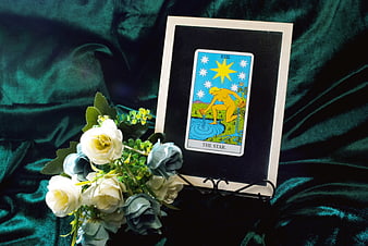The Star Tarot Card Displayed With White And Blue Roses On Green Velvet