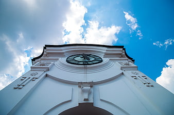 Low angle view of white clock tower against blue sky