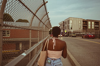 Woman walking on urban bridge at dusk
