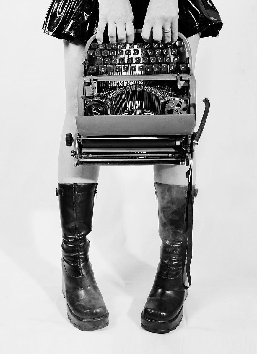 Conceptual Black and White Photo of Woman Holding Open Typewriter
