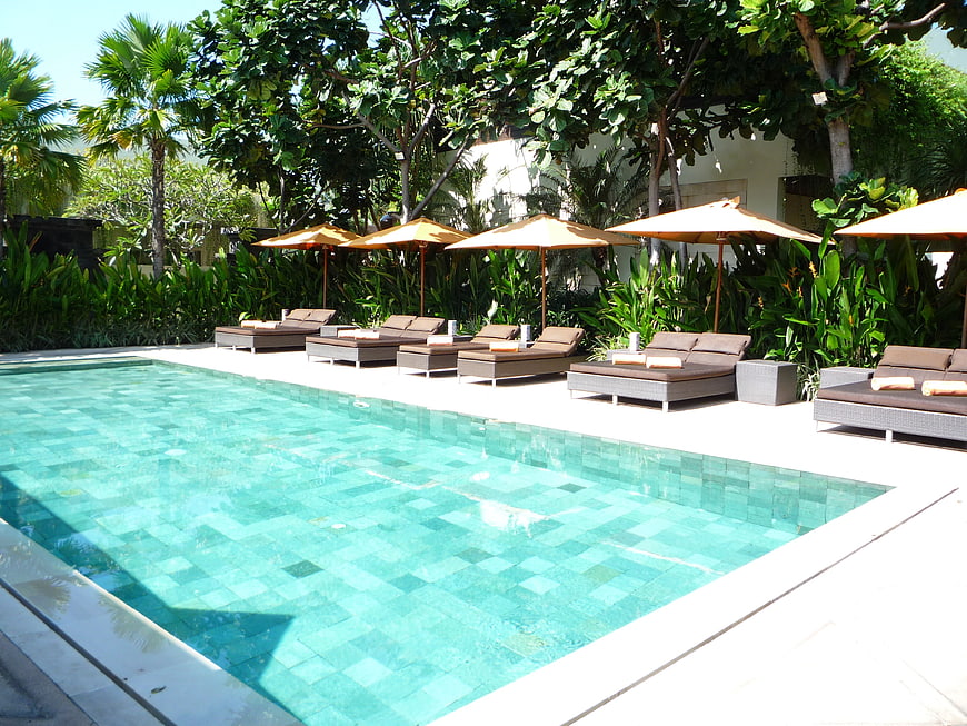 Luxury Resort Swimming Pool With Lounge Chairs And Tropical Greenery