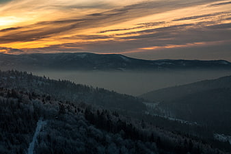Aerial View of Snowy Mountain Forest at Sunset