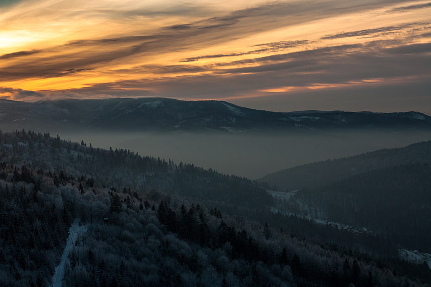 Aerial View of Snowy Mountain Forest at Sunset