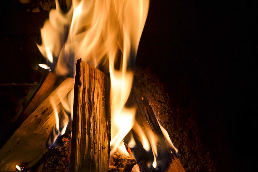 Close-up of burning wood logs with bright orange flames
