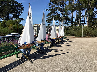 Row of miniature sailboats on park bench