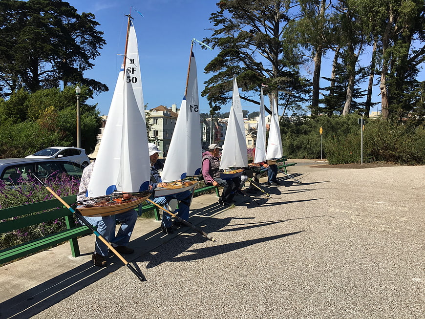 Row of miniature sailboats on park bench