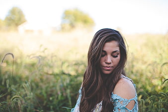 Serene young woman in blue lace dress in field