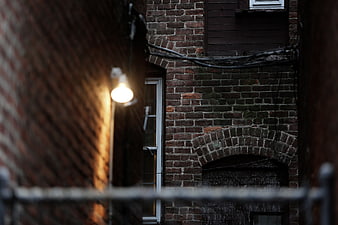 Narrow brick alleyway with warm light at dusk