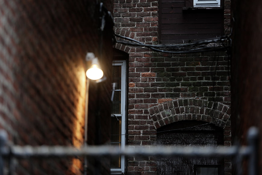 Narrow brick alleyway with warm light at dusk