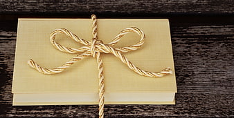 Gold and White Twisted Ribbon Bow on Beige Book Gift