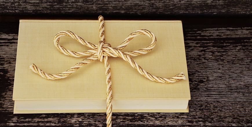Gold and White Twisted Ribbon Bow on Beige Book Gift