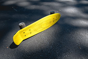 Yellow Penny Skateboard on Asphalt Pavement
