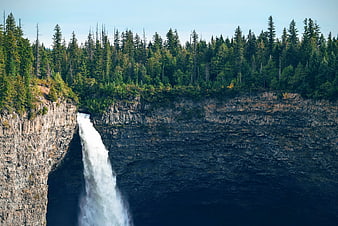 Majestic waterfall cascading down a rocky cliff into a deep gorge