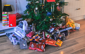 Christmas tree with pile of wrapped gifts and presents