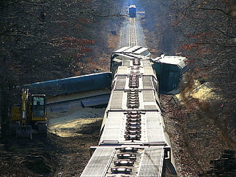 Overhead view of derailed train cars in forest