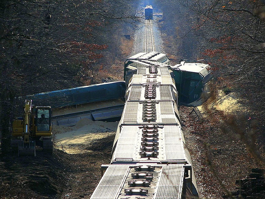 Overhead view of derailed train cars in forest