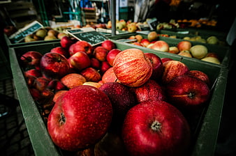 Fresh Red Apples in Green Crates at Farmers Market