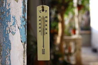 Outdoor Thermometer Hanging On Weathered Blue And White Wooden Post