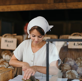 Female Baker Wrapping Bread in Rustic Market Stall