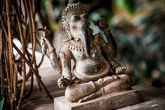 Weathered Stone Ganesha Statue in Serene Temple Setting