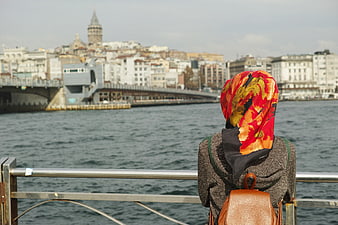Woman in colorful hijab overlooking Istanbul waterfront and Galata Tower