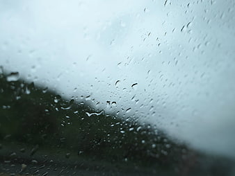 Raindrops on Window Glass with Blurred Background