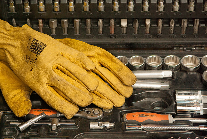 Yellow leather work gloves on mechanic tool set