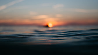 Blurred Sunset Over Ocean Waves with Soft Focus