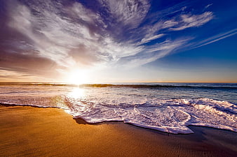 Golden Sunset Over Ocean Waves on Sandy Beach