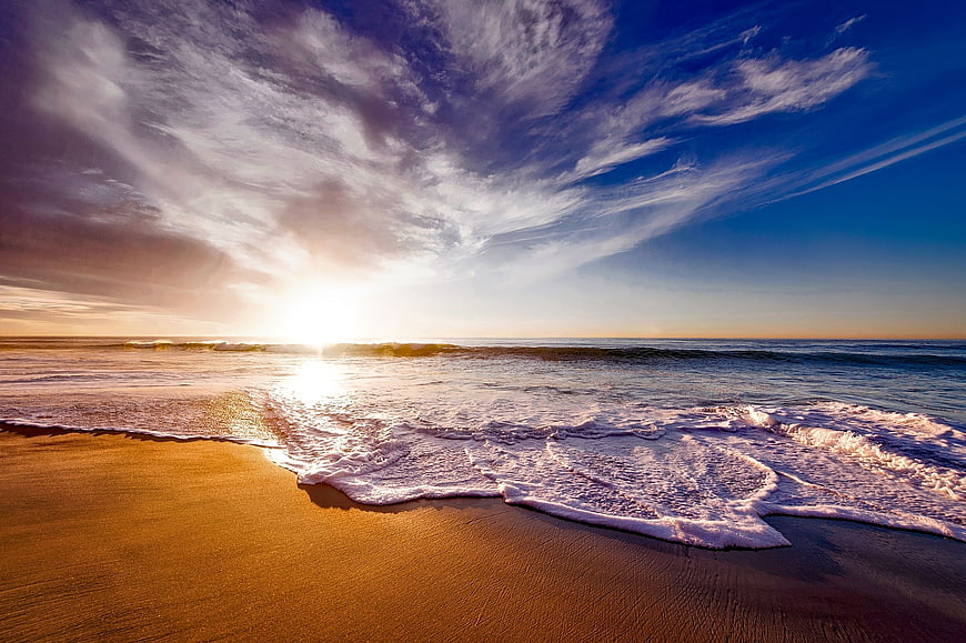 Golden Sunset Over Ocean Waves on Sandy Beach