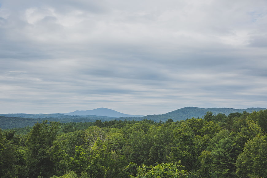 Scenic mountain landscape with green forest and cloudy sky