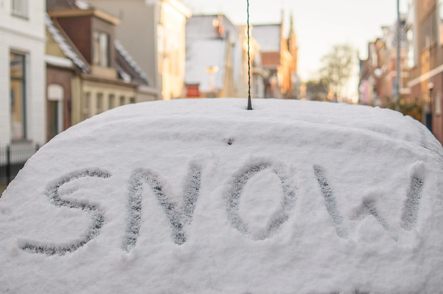 Word Snow Written on Snow-Covered Car Roof