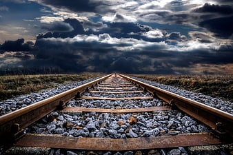 Dramatic Railway Tracks Leading Into Stormy Clouds