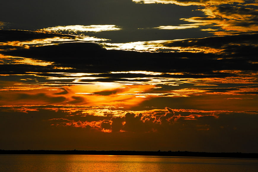 Dramatic Golden Sunset Over Calm Water Horizon