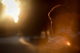 Silhouette of Man with Backpack Walking at Sunset