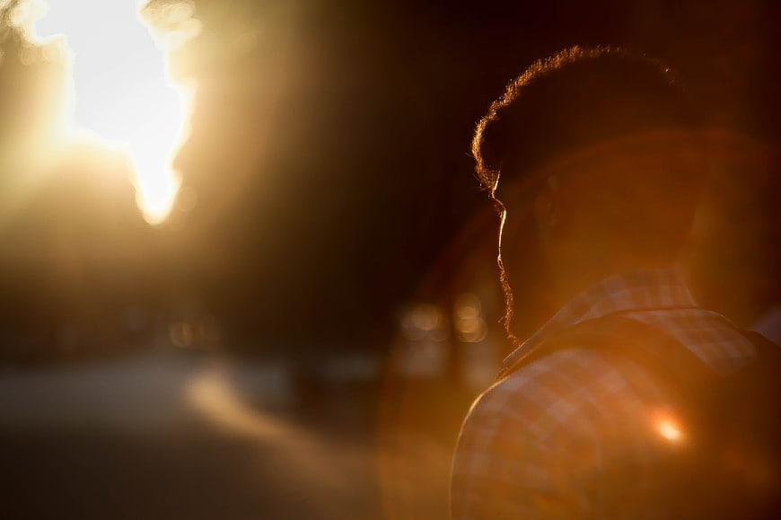 Silhouette of Man with Backpack Walking at Sunset